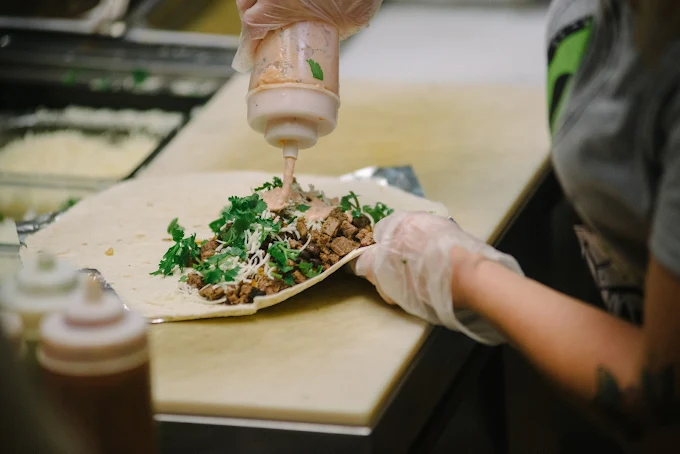 Smoked meat burrito being built by hand